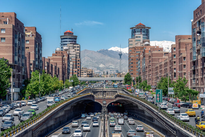 Tehran,Iran,Famous view of Tehran,Flow of traffic inside, above and nearby around Tohid Tunnel with Milad Tower and Alborz Mountains