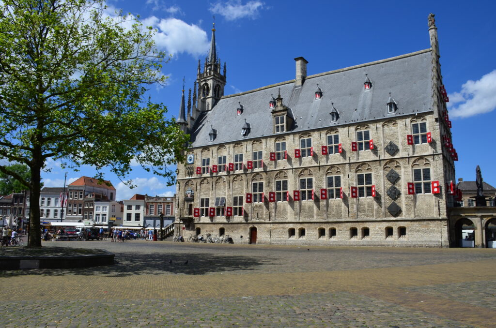 Market with the Gothic city Hall on a summer day in Gouda