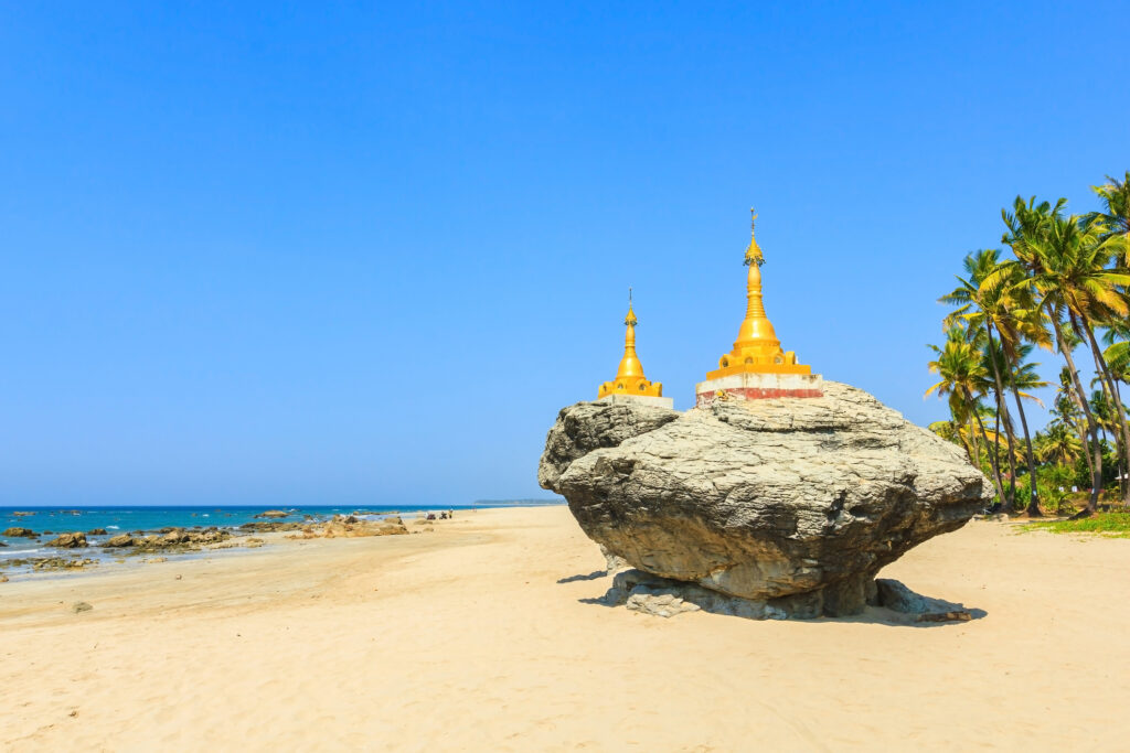 Two golden pagodas on rocks at Ngwe Saung