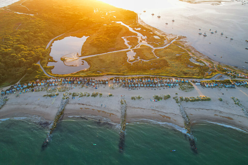 An aerial view of a sandy beach at sunset in Hengistbury