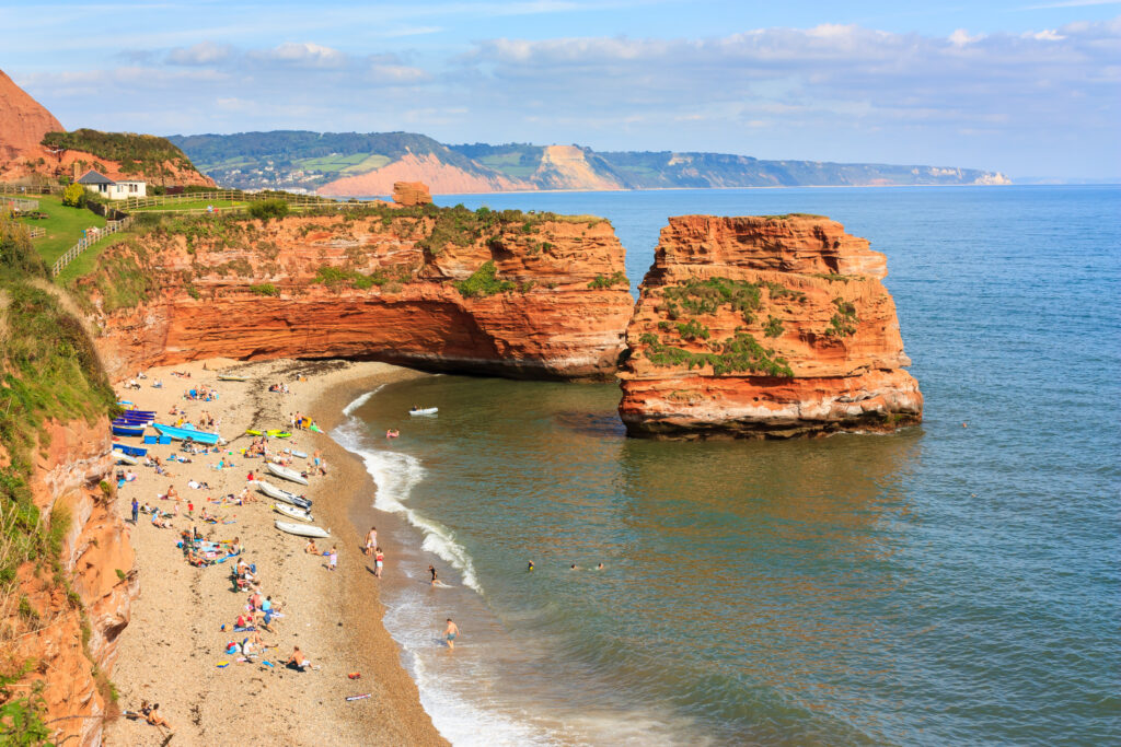 Dramatic red Jurassic cliffs and sea stacks at Ladram Bay Devon England