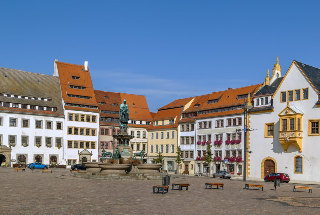 Historic houses and fountain with statue of the town founder on main square in Freiberg, Saxony,Germany