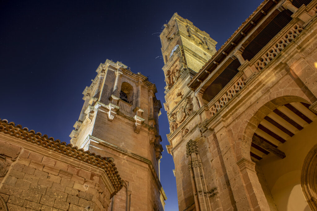 Detail of the towers of El Tardon and La Trinidad in the Plaza Mayor of Alcaraz, Albacete, Castilla la Mancha, Spain illuminated at dusk