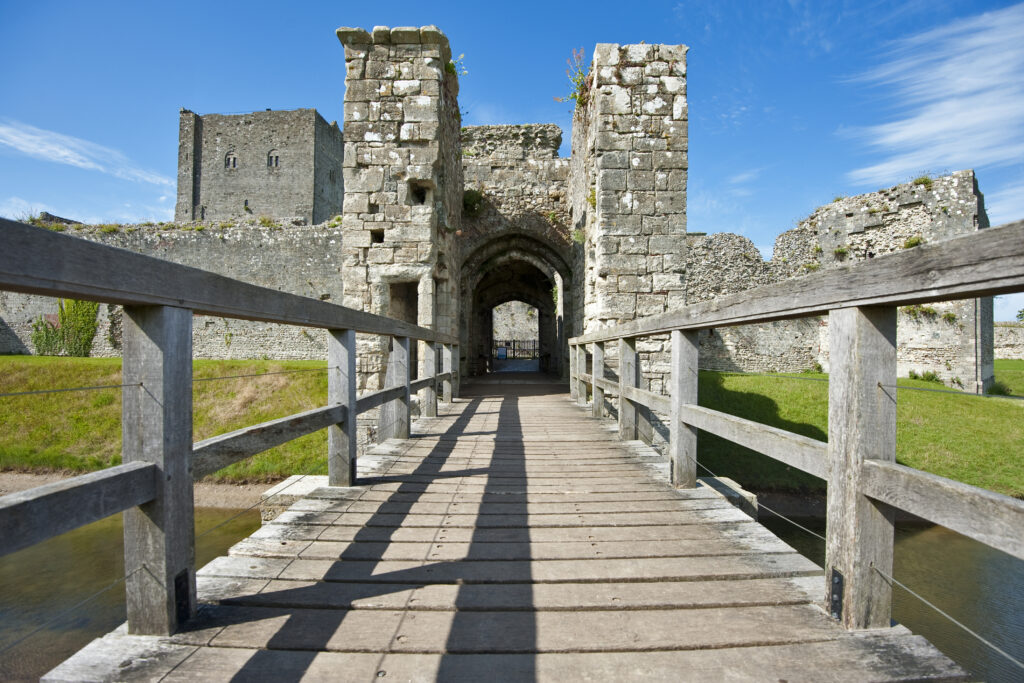 Portchester Castle in Hampshire viewed over a wooden bridge on a beautiful day