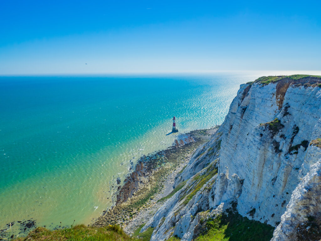View of the white chalk headland cliffs and Beachy Head Lighthouse in the Seven Sisters National park, Eastbourne, East Sussex, England, UK