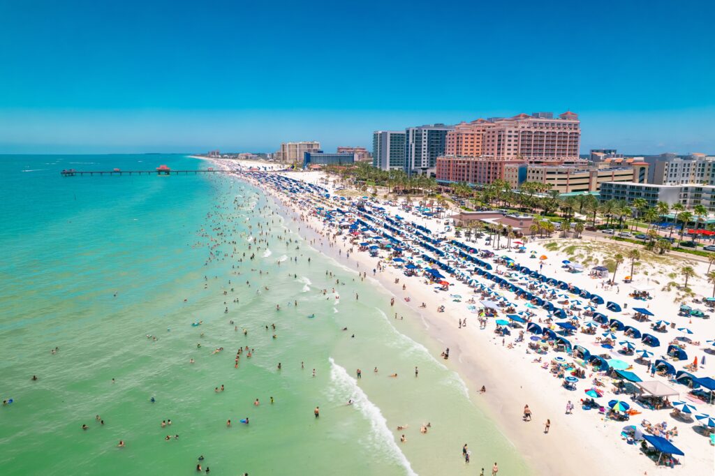 Beach. Panorama of Clearwater Beach FL. Florida Beaches. Summer vacations. Beautiful View on Hotels and Resorts on Island. Turquoise color of Ocean water. American shore Gulf of Mexico. Sunny Day