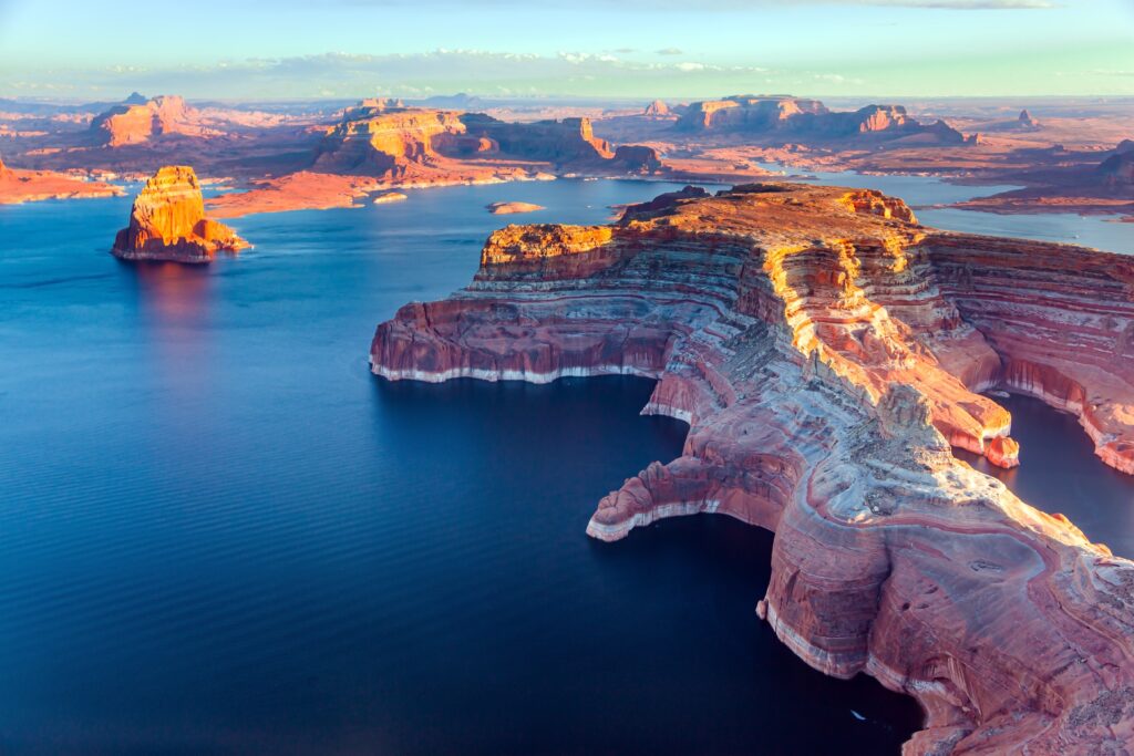 Lake Powell is a reservoir on the Colorado River located in the U.S. states of Utah and Arizona. Small islands stick out of the water.  Landscape under the wing of an airplane