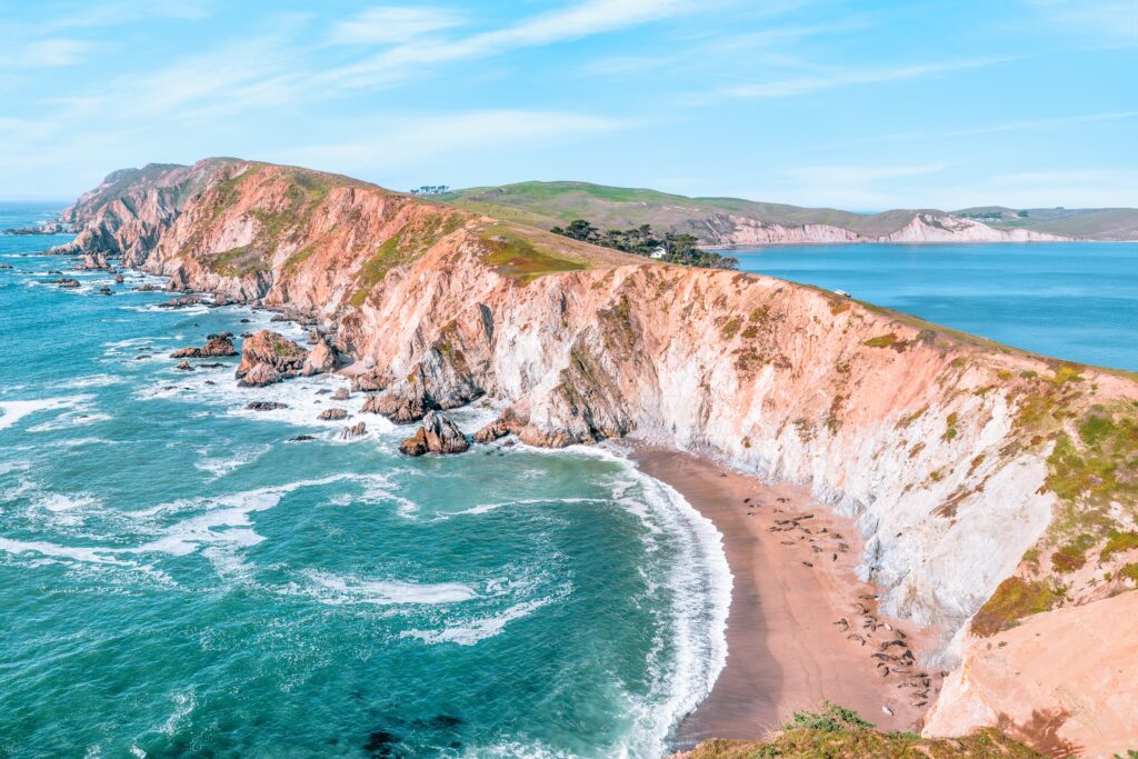 Breathtaking aerial view of Point Reyes, California, showcasing dramatic coastal cliffs surrounded by the Pacific Ocean. A stunning destination for nature lovers, photographers, and outdoor
