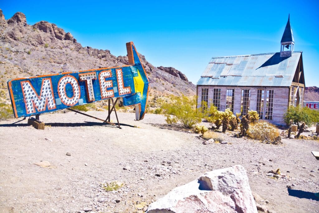 Old motel sign pointing towards old church in Nelson Ghost Town Nevada