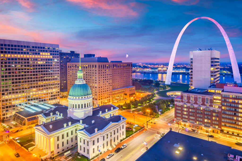St. Louis, Missouri, USA downtown cityscape with the arch and courthouse at dusk.