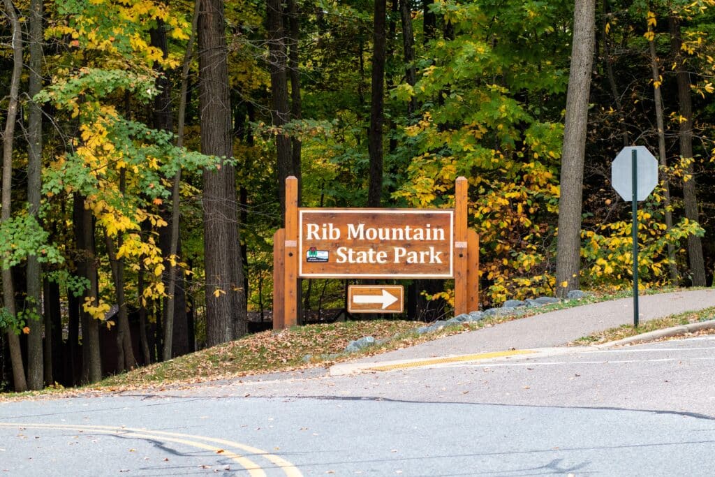 Rib Mountain State Park sign pointing to Park Road headed for Granite Peak ski area in Wausau, Wisconsin, horizontal