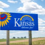 Kansas welcomes you - welcome roadside sign with a popular Latin phrase ad astra per aspera (through hardships to the stars), driving and travel concept