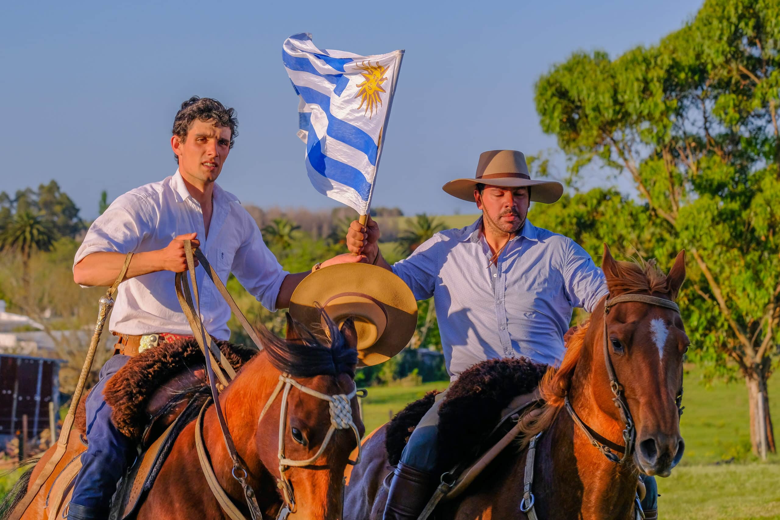Gauchos riding horses and waving the Uruguayan flag in Uruguay, South America