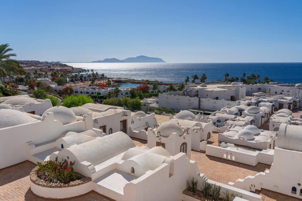 White wall buildings near Red sea on the tropical beach on sunny day in resort town Sharm El Sheikh, Egypt, architecture concept