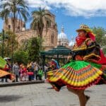 Cuenca, Ecuador - January 14, 2023: "Pase del Niño Viajero" celebration. A group of folk dancers from Cayambe Canton, Pichincha Province in colorful traditional dress in historical center of Cuenca