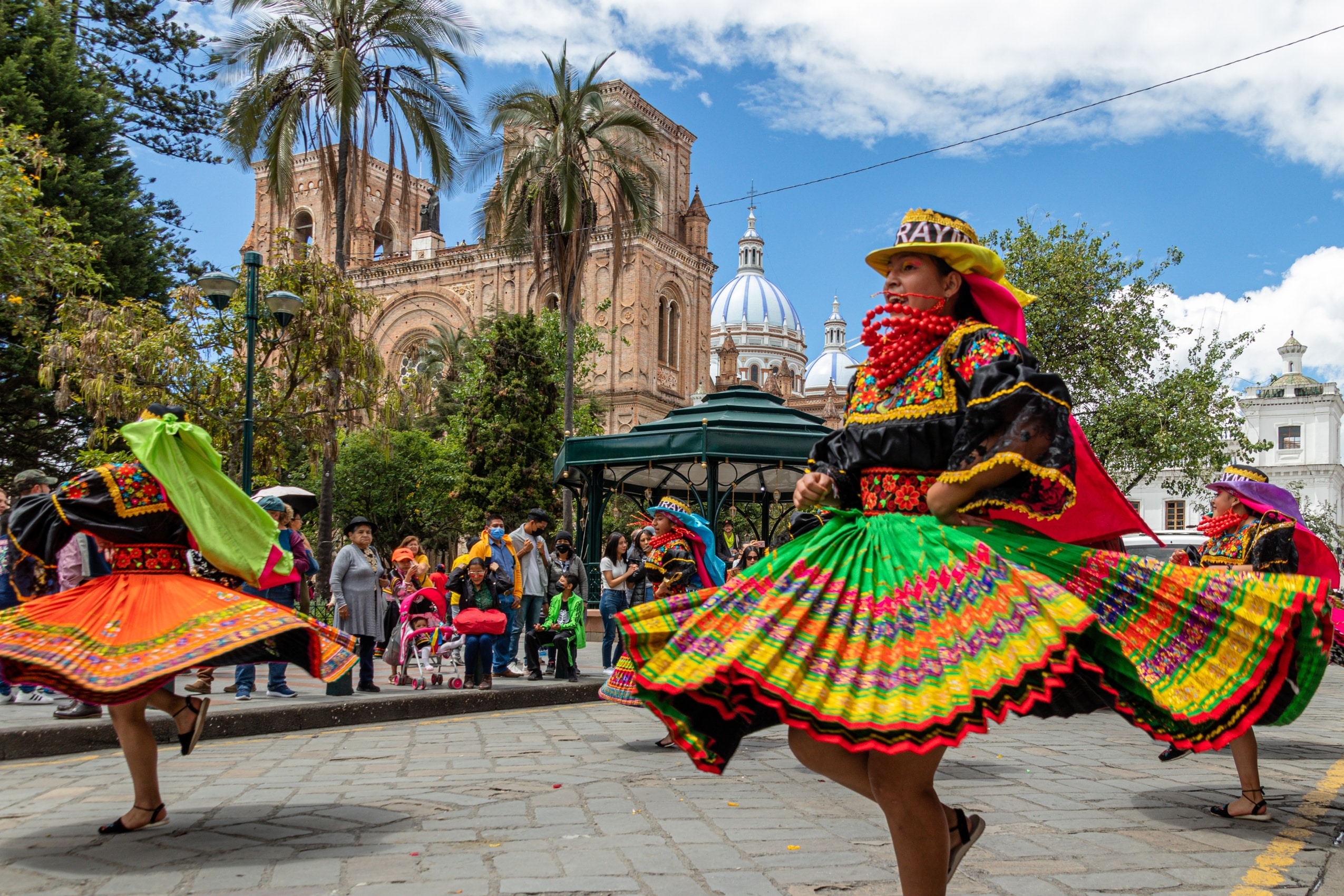 Cuenca, Ecuador - January 14, 2023: "Pase del Niño Viajero" celebration. A group of folk dancers from Cayambe Canton, Pichincha Province in colorful traditional dress in historical center of Cuenca
