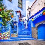 Chefchaouen, Morocco. Blue staircase and wall decorated with colorful flowerpots, North Africa travel destination.