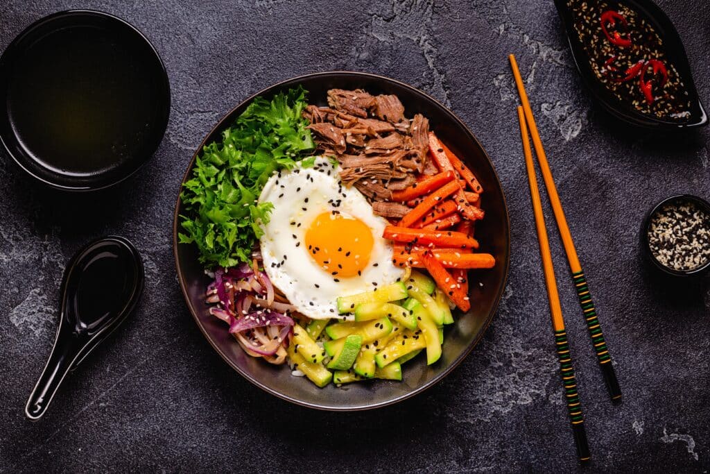 Traditional Korean bibimbap with rice, vegetables, beef, and fried egg