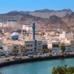 Panoramic view of Muscat Muttrah district with waterfront, traditional architecture in Oman during sunny day