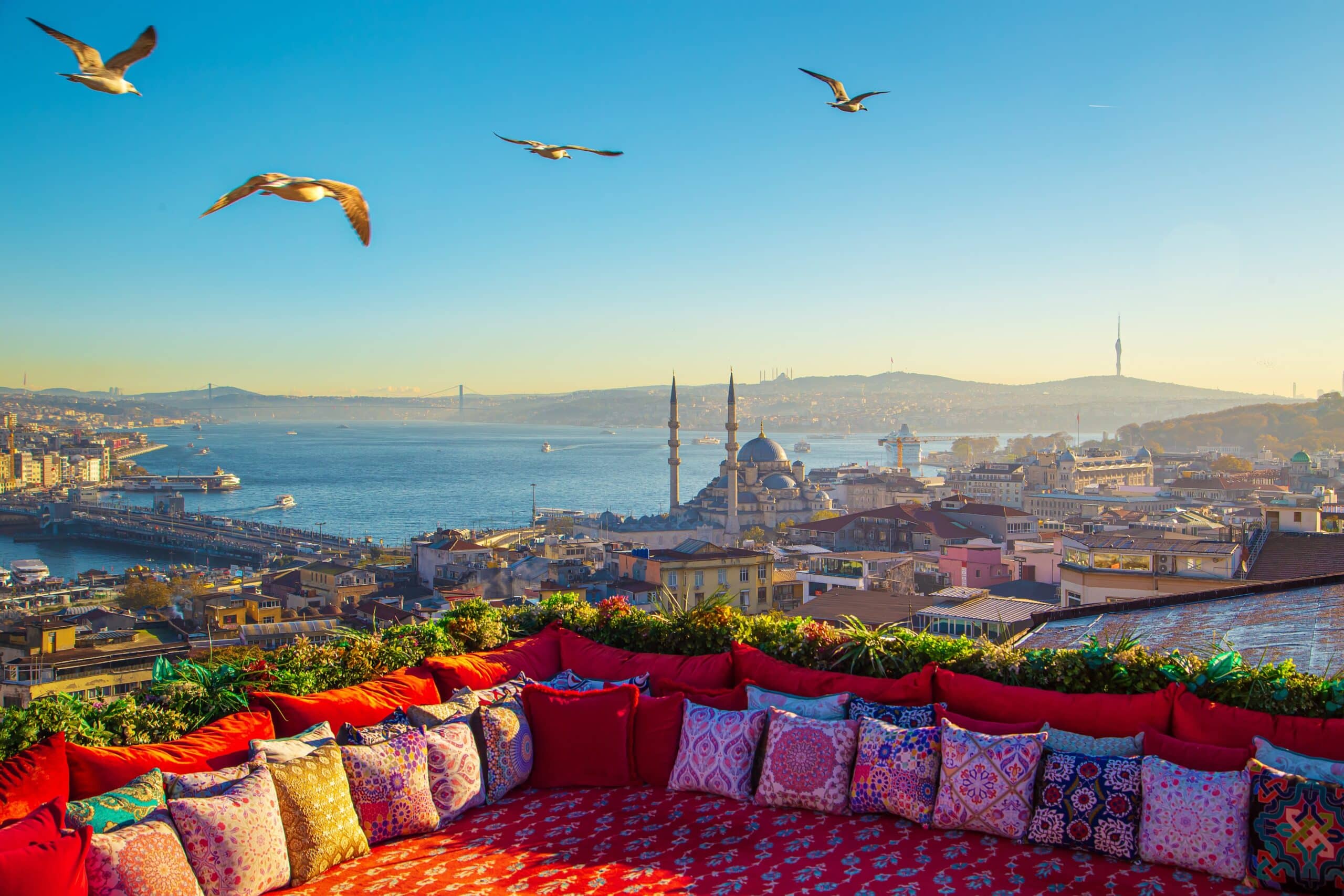Magnificent panoramic views of the Bosphorus and the historic center of Istanbul. Istanbul rooftop with traditional colorful Turkish carpet and pillows.