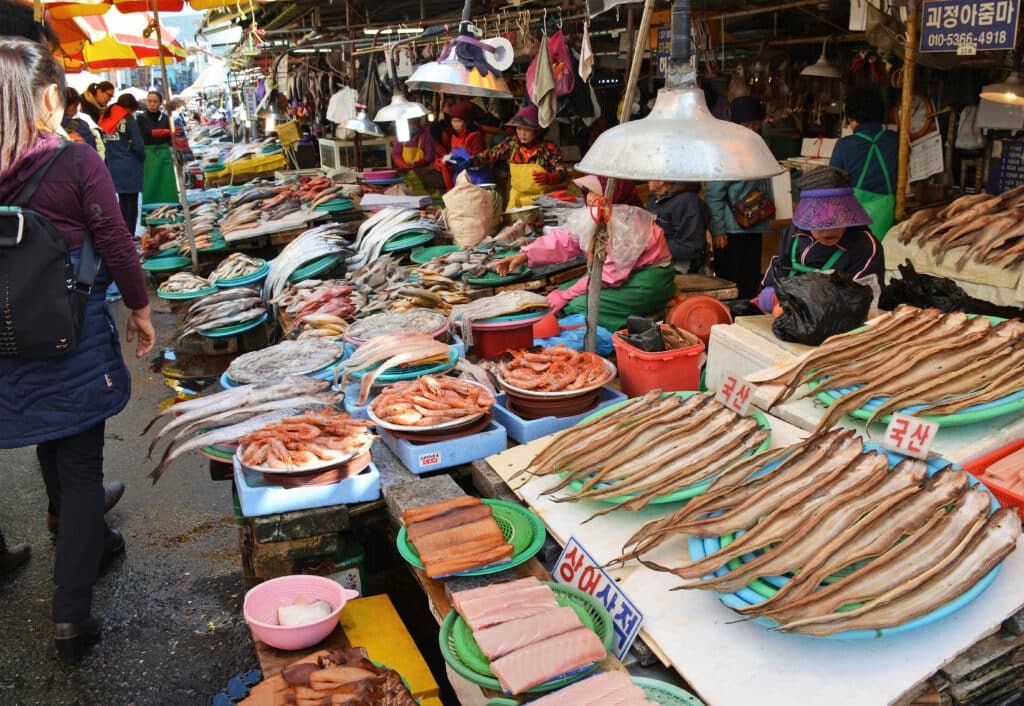 Fresh seafood stalls at Jagalchi Fish Market in Busan with vendors and fish displays