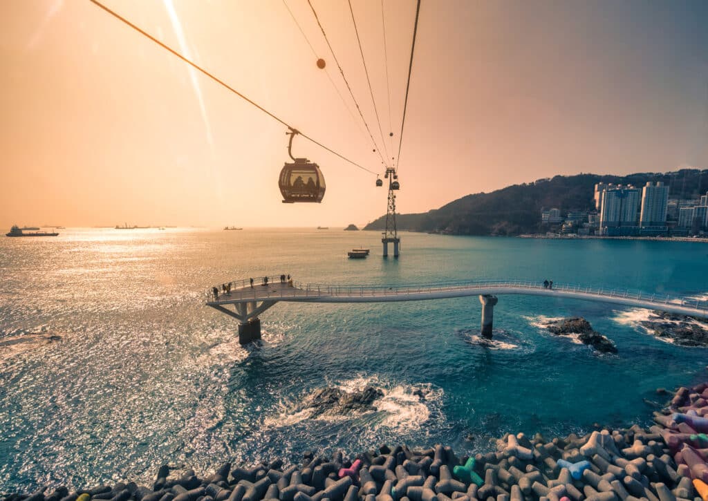Songdo cable car and curved skywalk over the ocean in Busan at sunset