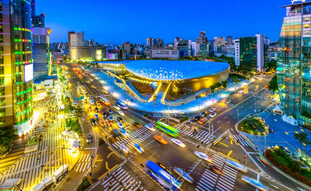 Dongdaemun Design Plaza in Seoul at night with traffic and illuminated modern architecture