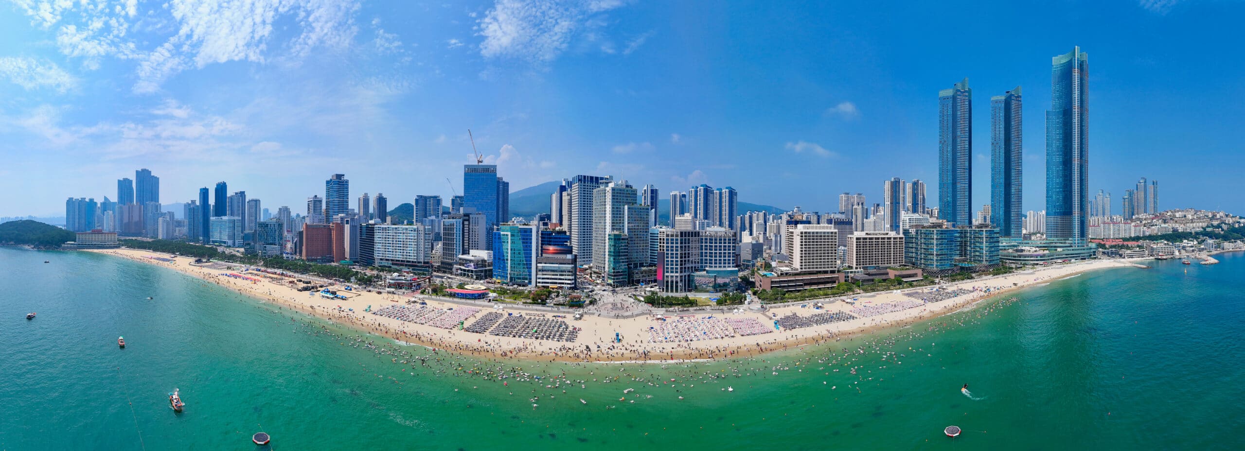 Aerial view of Haeundae Beach with turquoise water and city skyline