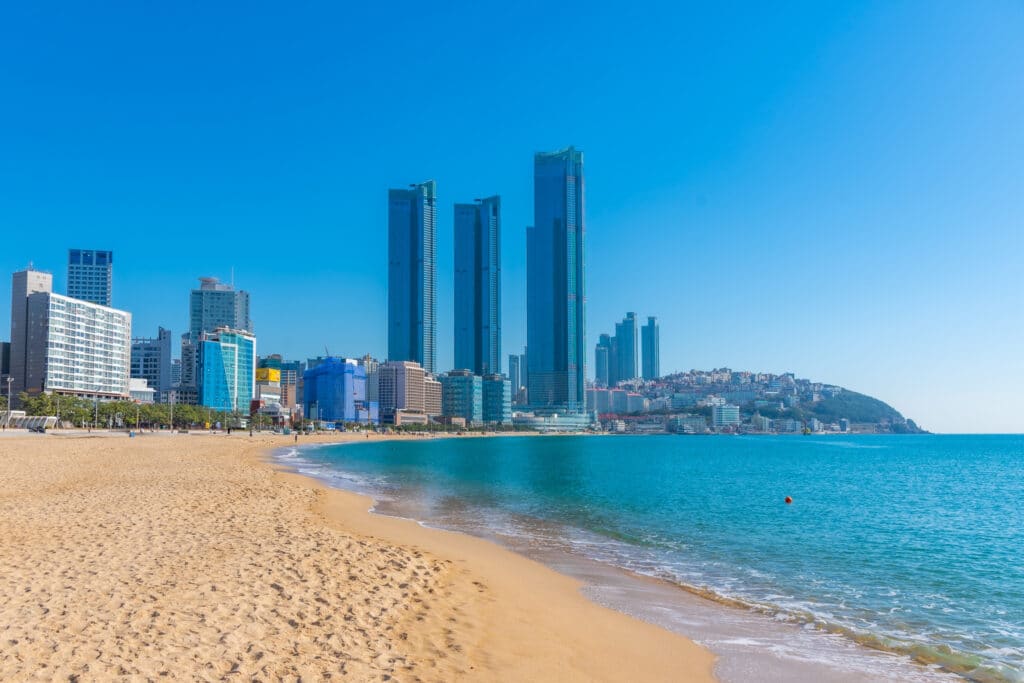 Haeundae Beach in Busan with sandy shoreline, calm sea, and city skyline