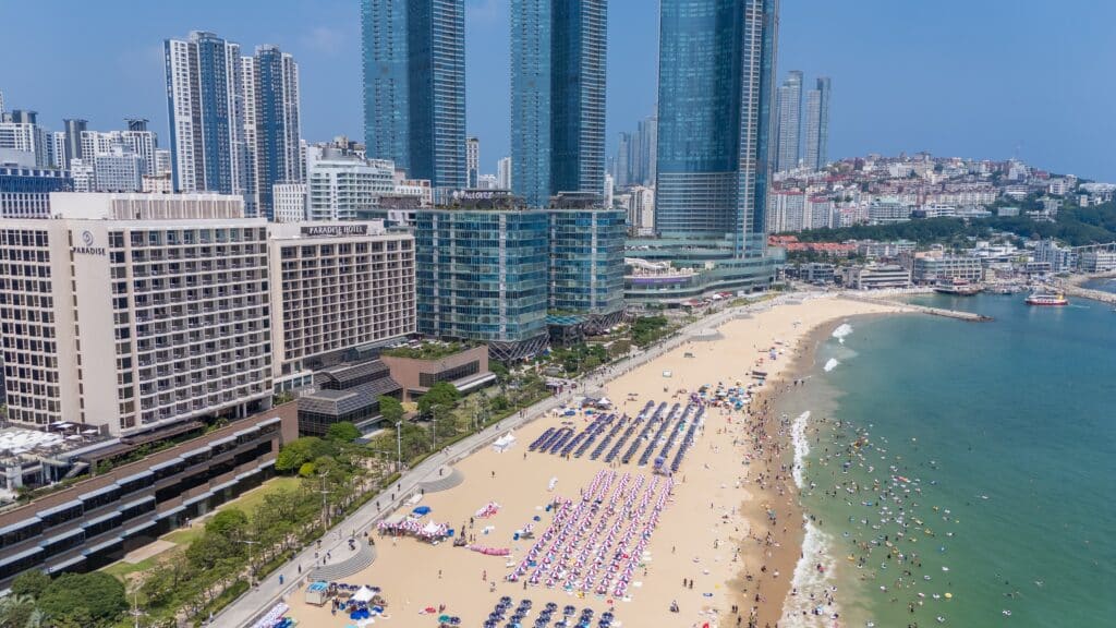 Haeundae Beach in Busan with umbrellas and city skyline during summer