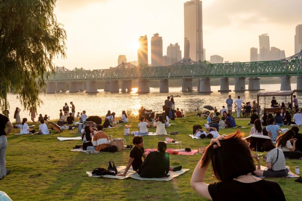 People enjoying a picnic along the Han River at sunset in Seoul South Korea