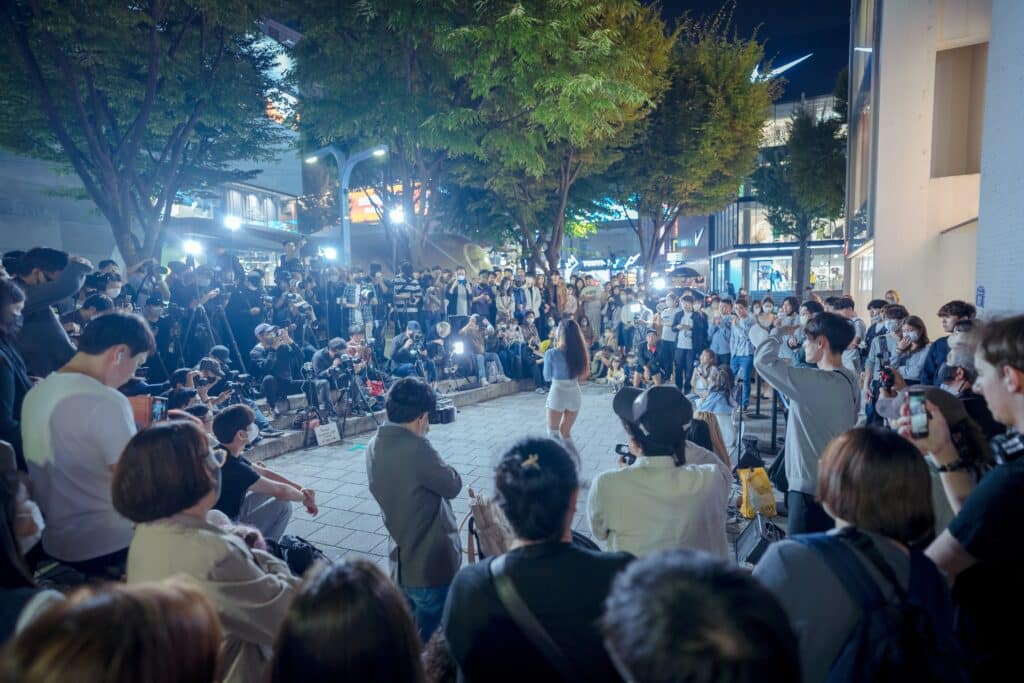 Street performance in Hongdae Seoul surrounded by crowd and photographers at night