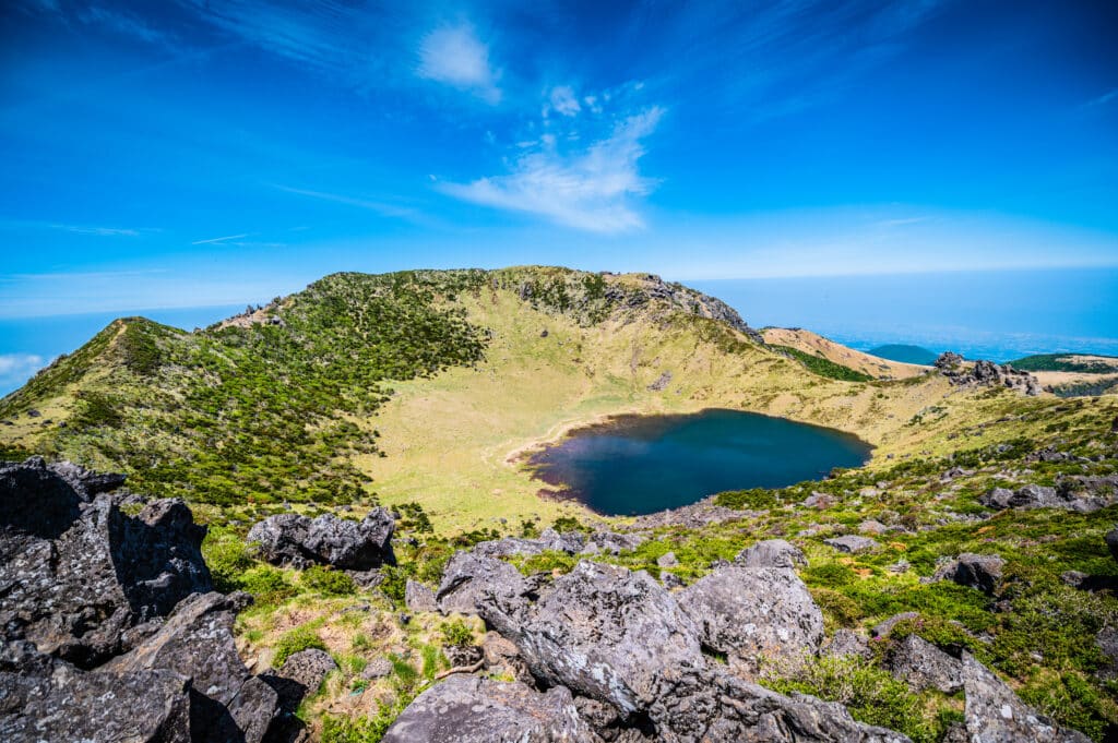Volcanic crater landscape on Jeju Island with lake and mountains