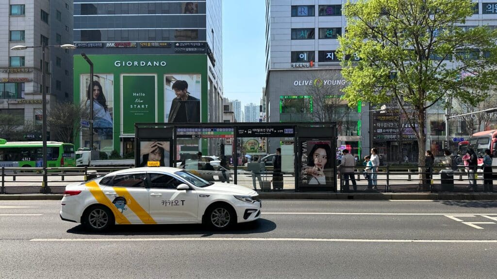 Kakao taxi driving through a street in Seoul South Korea with modern buildings