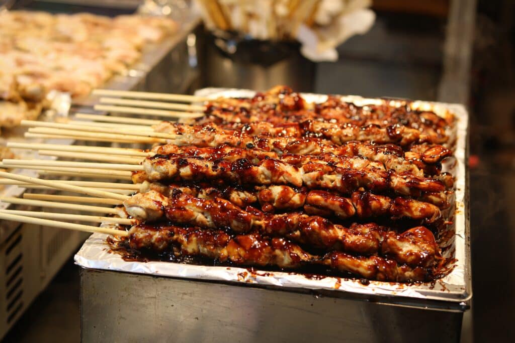 Korean dakkochi grilled chicken skewers with sweet spicy sauce at a street food stall