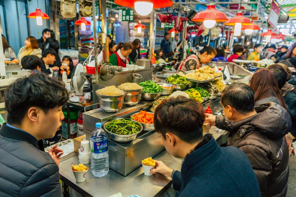 Busy Korean street food market with food stalls and visitors