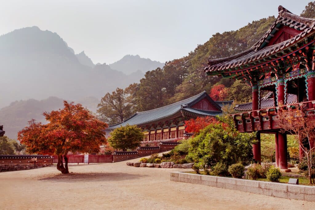 Traditional temple surrounded by autumn trees and mountains in South Korea