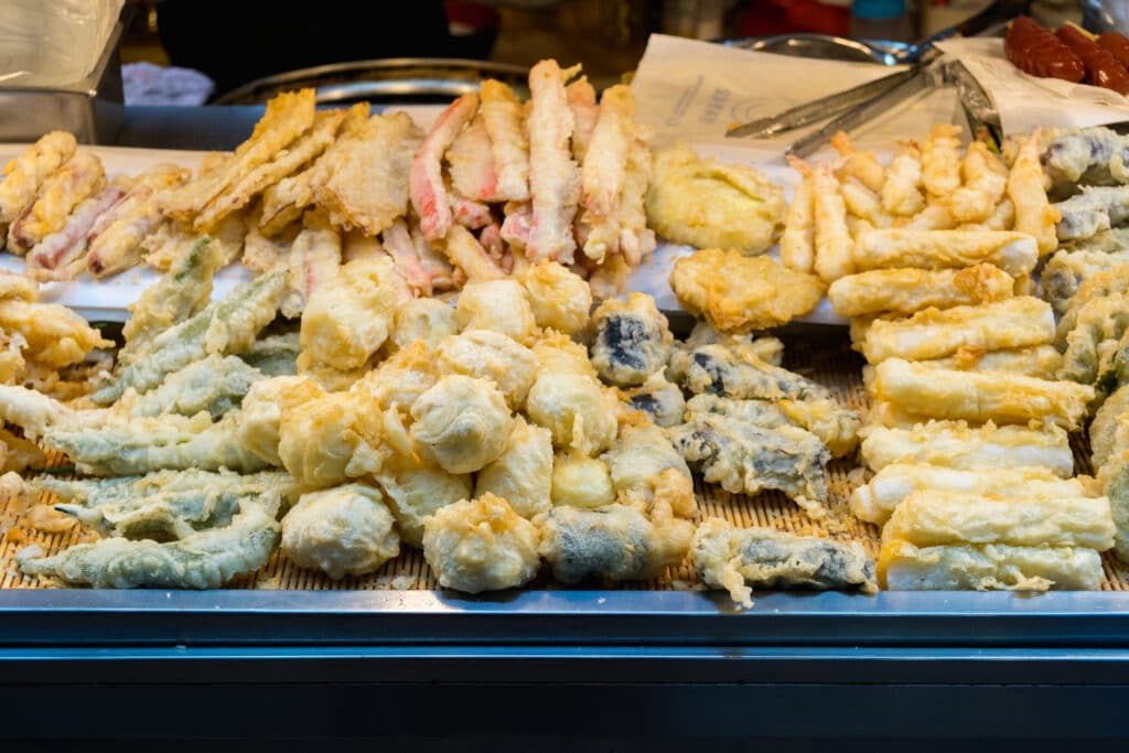 Assorted Korean tempura twigim including vegetables and seafood at a street food stall