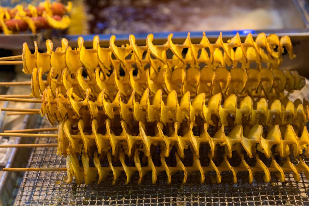 Korean tornado potato spiral fried on a skewer at a street food market
