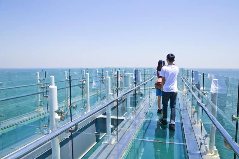 Visitors walking on Oryukdo Skywalk glass platform above the ocean in Busan