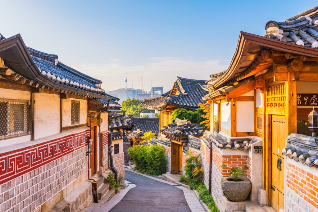 Traditional Korean houses in Bukchon Hanok Village with Seoul skyline in the background
