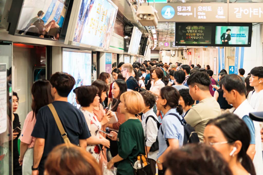 Crowded subway platform in Seoul showing commuters and train signage in South Korea