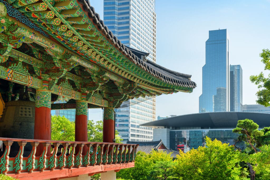 Traditional Korean temple architecture in Seoul with modern skyscrapers in the background