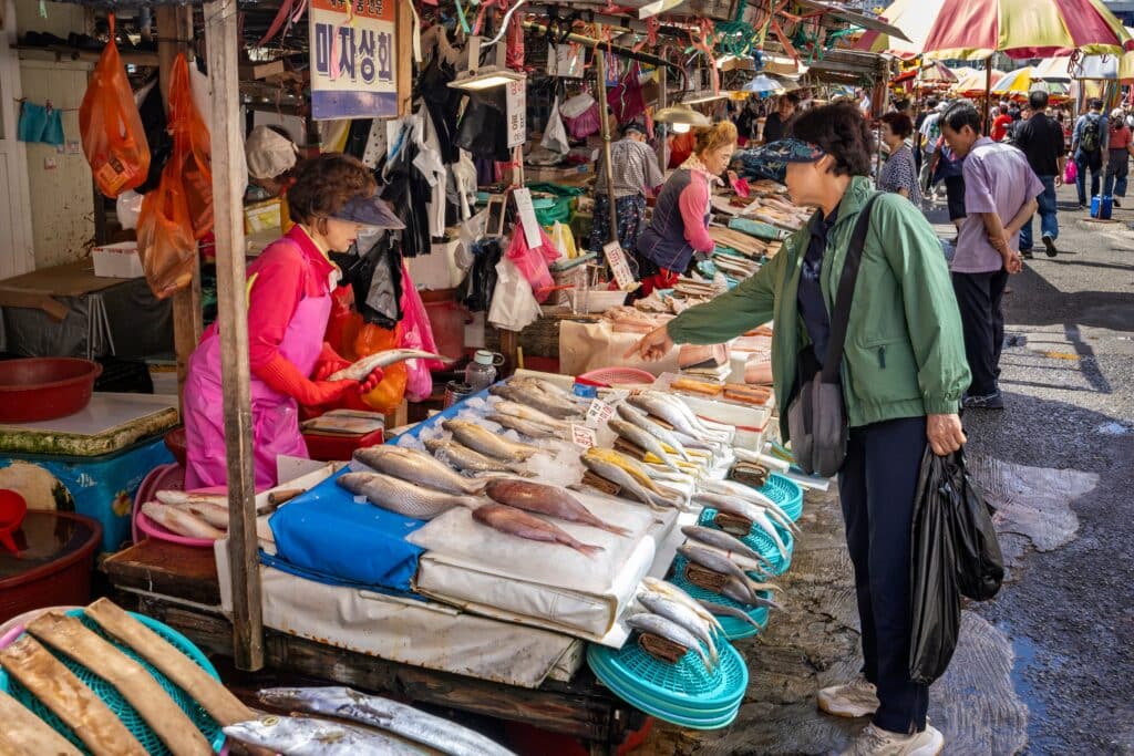 Customer pointing at fish on market stall in Jagalchi Fish Market, Busan, South Korea
