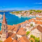 A picturesque view of Milna, a traditional fishing village on Brac Island, Croatia, featuring its scenic marina, and the crystal-clear Adriatic Sea, making it a popular tourist destination