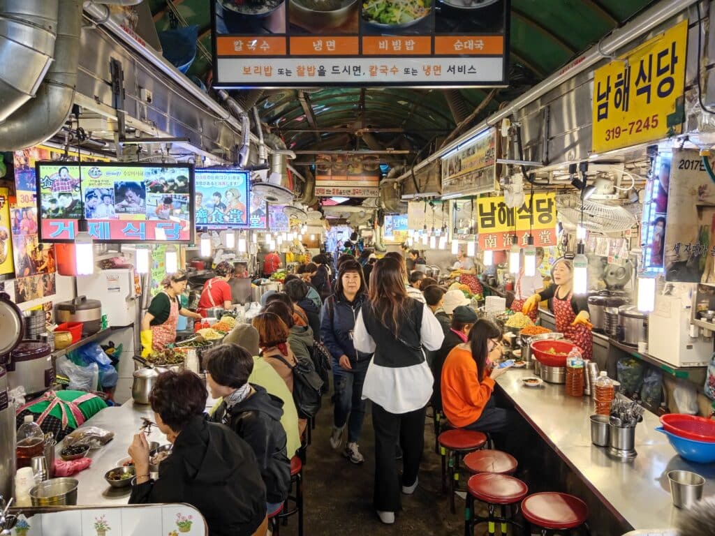 Street food vendor cooking Korean food at a market stall in Kalguksu Alley in Namdaemun Market in Seoul, South Korea