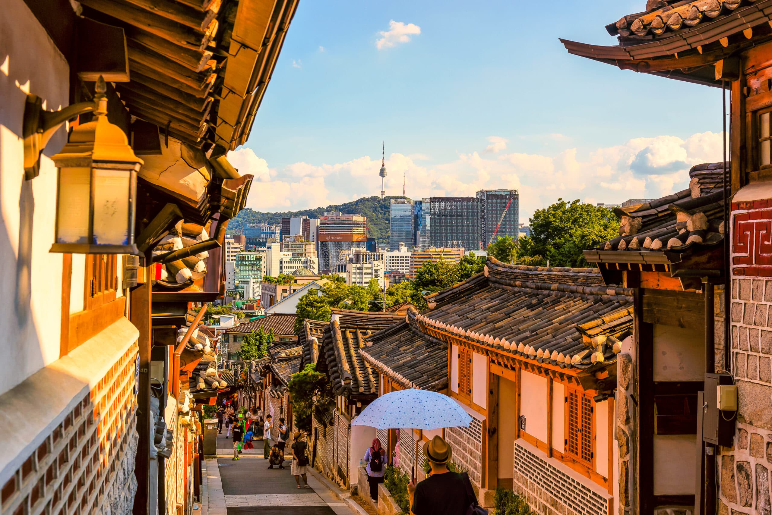 Bukchon Hanok Village in Seoul with traditional Korean houses and the modern city skyline in the background