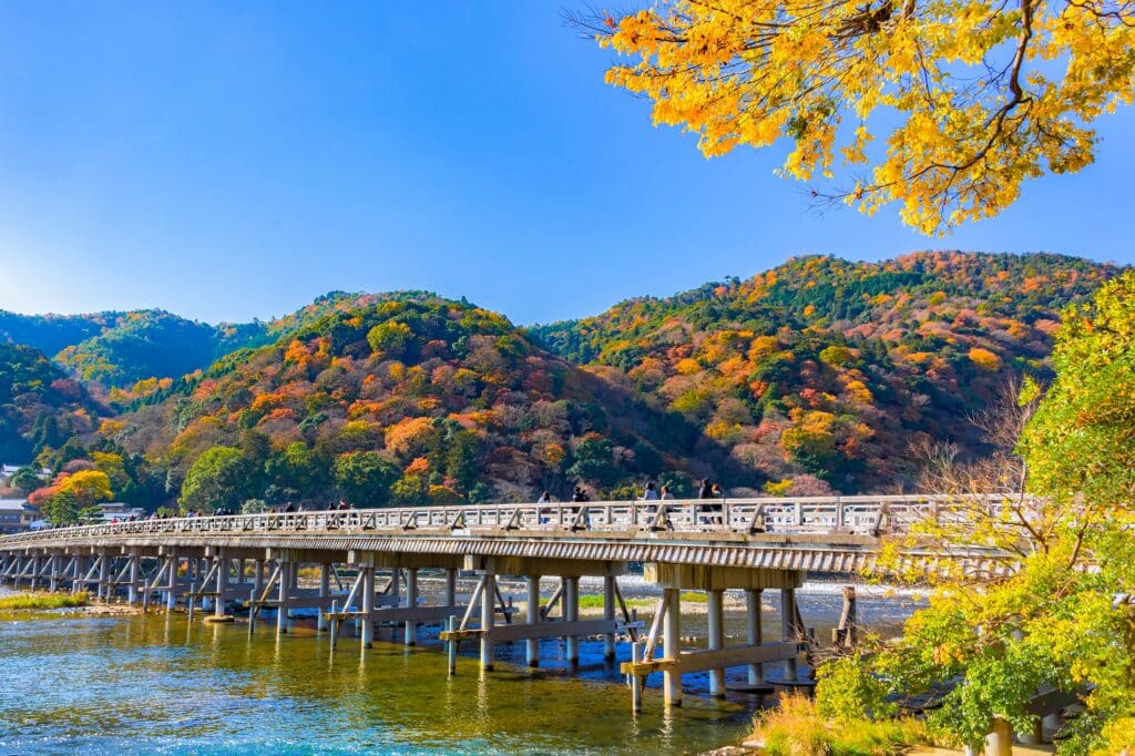 Togetsukyo Bridge in Arashiyama with autumn colors and mountains in Kyoto
