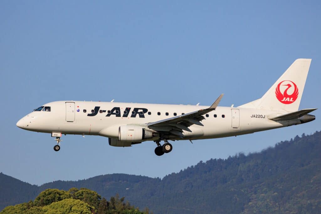 Domestic Japan Airlines aircraft flying over a mountainous landscape in Japan