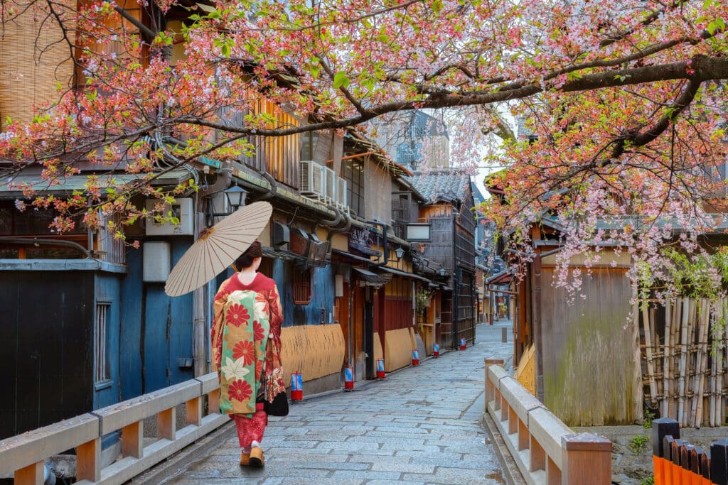 woman in kimono walking through Gion Kyoto street with cherry blossoms